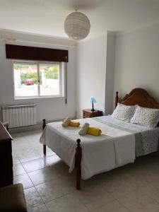 Un dormitorio con una cama grande y una ventana en Villa Abreu, en Esposende