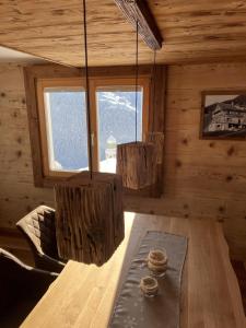 a dining room with a table and chandeliers in a cabin at Haus Schäfer Zita in Fontanella