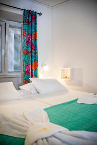 a bedroom with a large white bed with a window at Apartman Beppo in Rovinj