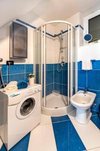 a blue and white bathroom with a washing machine at Apartman Beppo in Rovinj
