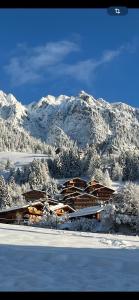 ein Gebäude mit schneebedeckten Bergen im Hintergrund in der Unterkunft Tirol Juwel in Alpbach