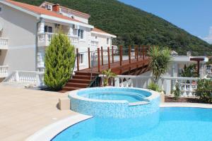 uma piscina em frente a uma casa em Elegance Duplexes by Monte Aria em Herceg Novi