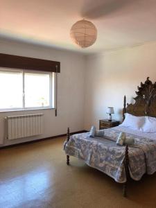 a bedroom with a large bed and a large window at Villa Abreu in Esposende
