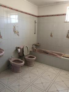 a bathroom with two toilets and a bath tub at Villa Abreu in Esposende