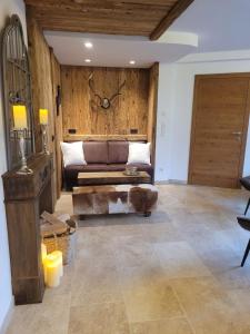 a living room with a couch and a wooden wall at Tirol Chalet Brixen in Brixen im Thale