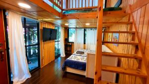 a bedroom with a bunk bed and a staircase in a house at บ้านนกฮูกอิงไม้ อิงมัจฉา in Ban Khlong Sai