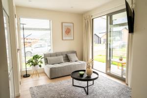 a living room with a couch and a table at Southern Peaks Hideaway in Frankton Wharf