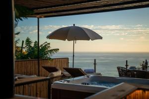 uma banheira de hidromassagem com vista para o oceano em Glamping Maracujá - Oasis Paradise em Ribeira Brava