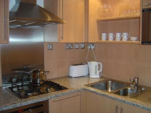 a kitchen with a stove top and a sink at Chelsea in London