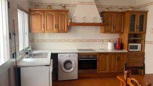 a kitchen with a washing machine and a sink at La Pontezuela in Chipiona