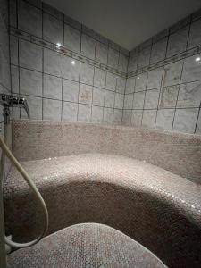 La salle de bains est pourvue d'une baignoire avec un tuyau. dans l'établissement Gästehaus Tauscher am Haldensee, à Haldensee