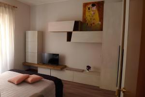 1 dormitorio con 1 cama y TV en la pared en Graziosa casetta vicino alla Metro, en Roma