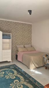 Johannesburg的住宿－Trendy Johannesburg Cottages，一间卧室配有一张床和图案墙壁