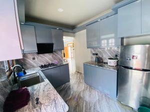 eine Küche mit Küchengeräten aus Edelstahl und blauen Schränken in der Unterkunft Sunset Chalet in Mullaittivu
