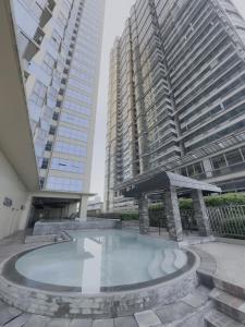 a swimming pool in the middle of two tall buildings at SnugglePod Condotel - Grand Riviera Suites in Manila