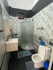 a bathroom with a shower and a toilet and a sink at Sunset Chalet in Mullaittivu