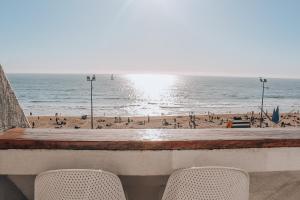 uma vista para a praia a partir de um bar com duas cadeiras em Departamento dúplex frente al mar en Reñaca em Viña del Mar
