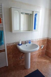 un bagno con un lavandino bianco e uno specchio di Appartamentino a Susegana a Susegana