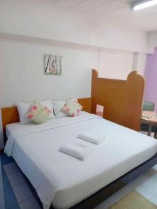 Un dormitorio con una cama blanca con toallas. en Mansion Sarasinee @ Chatuchak, en Bangkok