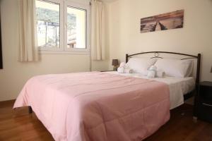a bedroom with a pink bed with two teddy bears on it at Aurora Family Loft in Nafplio