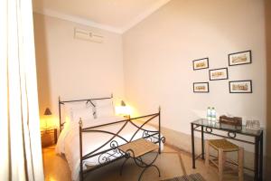 a bedroom with a bed and a desk in it at Riad El Gnaouia in Marrakesh