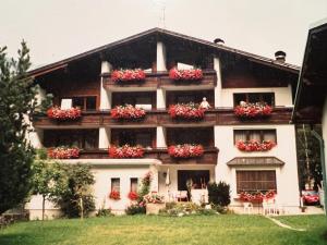 a building with flowers on the balconies of it at Gästehaus Tauscher am Haldensee in Haldensee