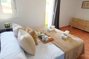 uma cama branca com uma bandeja de toalhas e velas em Apartamento en Roda de Berà em Roda de Bará