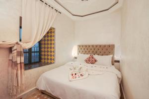 a bedroom with a white bed and a window at Riad Azalia in Marrakech