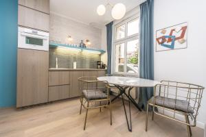 - une cuisine avec une table et des chaises dans la chambre dans l'établissement DR Apartments - Salt, à Sopot