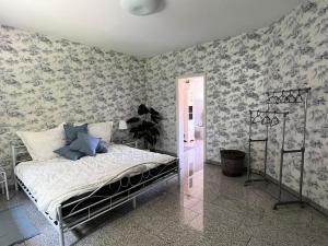 1 dormitorio con 1 cama en una habitación con papel pintado en Amazing House in Kaiserslautern, en Kaiserslautern