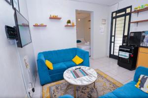a living room with a blue couch and a table at Cozy Studio along Ngong road-Nairobi in Nairobi