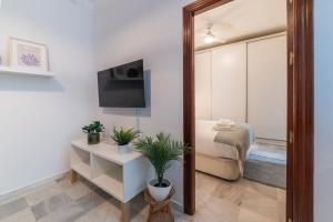 ein Zimmer mit einem Spiegel und ein Schlafzimmer mit einem Bett in der Unterkunft AlohaMundi Torres in Sevilla