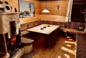 ein Esszimmer mit einem Tisch und einem Kamin in der Unterkunft Fleissner Hütte in Innerkrems