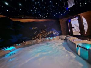 a hot tub in a room with a view of a city at Le Chalet Loft Spa in Calais