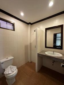 uma casa de banho com um WC, um lavatório e um espelho. em Baan Kingkeaw Thamdee Patong em Patong Beach