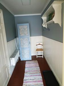 Habitación pequeña con puerta azul y alfombra. en Furulund en Gällö