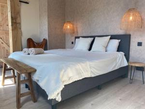 um quarto com uma cama grande e toalhas em d'Oude Smidse em Zuienkerke