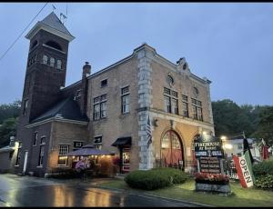 un gran edificio de piedra con una torre de reloj en Firehouse Inn en Barre