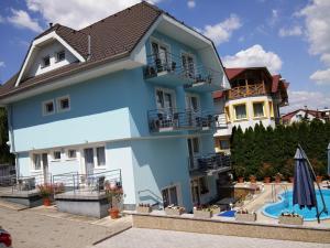 una casa azul con piscina frente a ella en Blue Mediterran Apartment House, en Balatonfüred