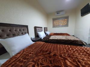a hotel room with two beds and a window at Petraone in Wadi Musa