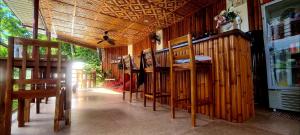 un restaurante con paredes de madera, mesas y sillas en Roos Guesthouse, en Moalboal