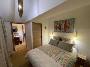 a bedroom with a large white bed with two pillows at Au bal des hirondelles in Andé