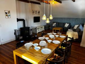einen Holztisch mit Tellern und Stühlen im Wohnzimmer in der Unterkunft Storchenhof in Eutin