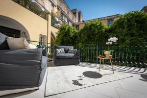 een patio met 2 stoelen en een tafel bij Downtown Napoli b&b - e si nun canto moro in Napels