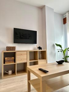 sala de estar con TV de pantalla plana en una pared blanca en Lemos Sol, en Monforte de Lemos