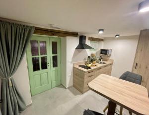 eine Küche mit einer grünen Tür und einem Tisch in der Unterkunft Vila Imenja in Šmartno