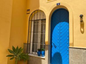 a blue door in a building with two windows at Apartamento Jema El Bajondillo in Torremolinos