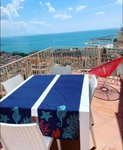 una mesa con un mantel azul y blanco en el balcón en Ti racconto il mare, en Salerno