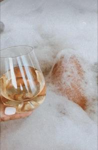 a person holding a glass of wine in the snow at Jacuzzi Loft & Sauna Sanctuary in Katowice