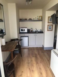 a small kitchen with a table and a microwave at The Snug, Ardfert Village in Ard Fhearta